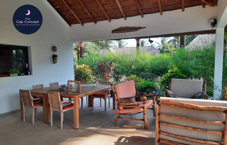 Terrasse avec salon de jardin espace conviviale pour les repas en plein air décor de jardin exotique fleuri et arboré idéal pour les vacances